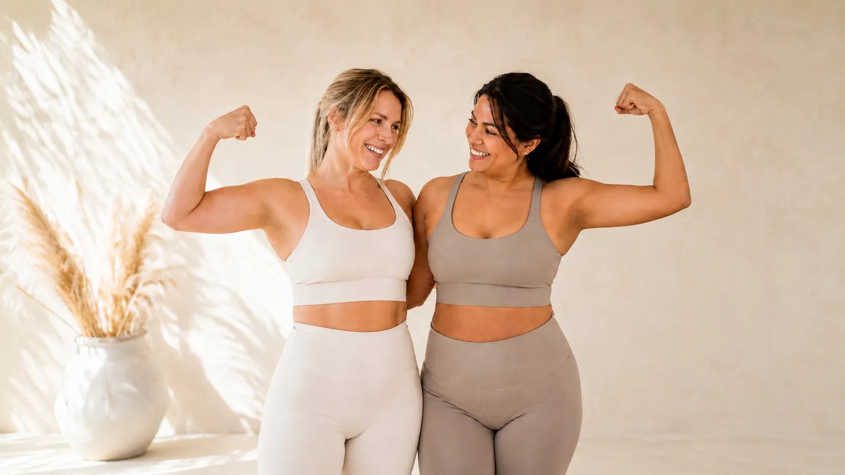 Two women in workout clothes flexing and smiling – personalized wellness with VEVArx