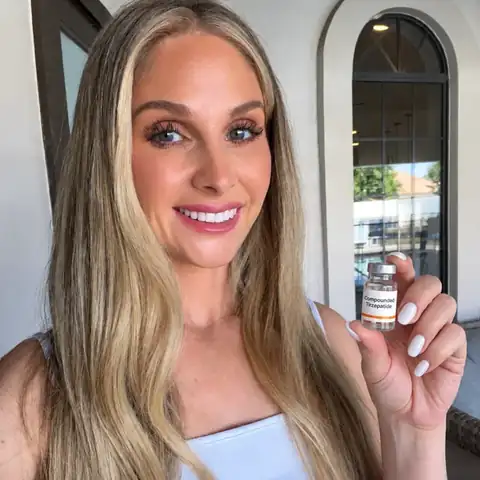 Smiling woman holding a vial of compounded Tirzepatide